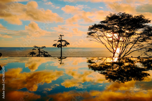 Clouds reflecting in shiny pond at sunset, Dominical, Costa Rica photo