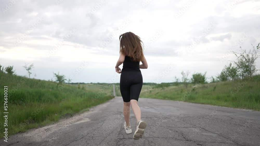 Runner girl. happy girl run along rural road. Way to success. Active lifestyle winner. Summer run outdoors. Girl run to success on rural road. Difficult way to overcome difficulties. Healthy lifestyle Runner girl. happy girl run along rural road. Way to success. Active lifestyle winner. Summer run outdoors. Girl run to success on rural road. Difficult way to overcome difficulties. Healthy lifestyle