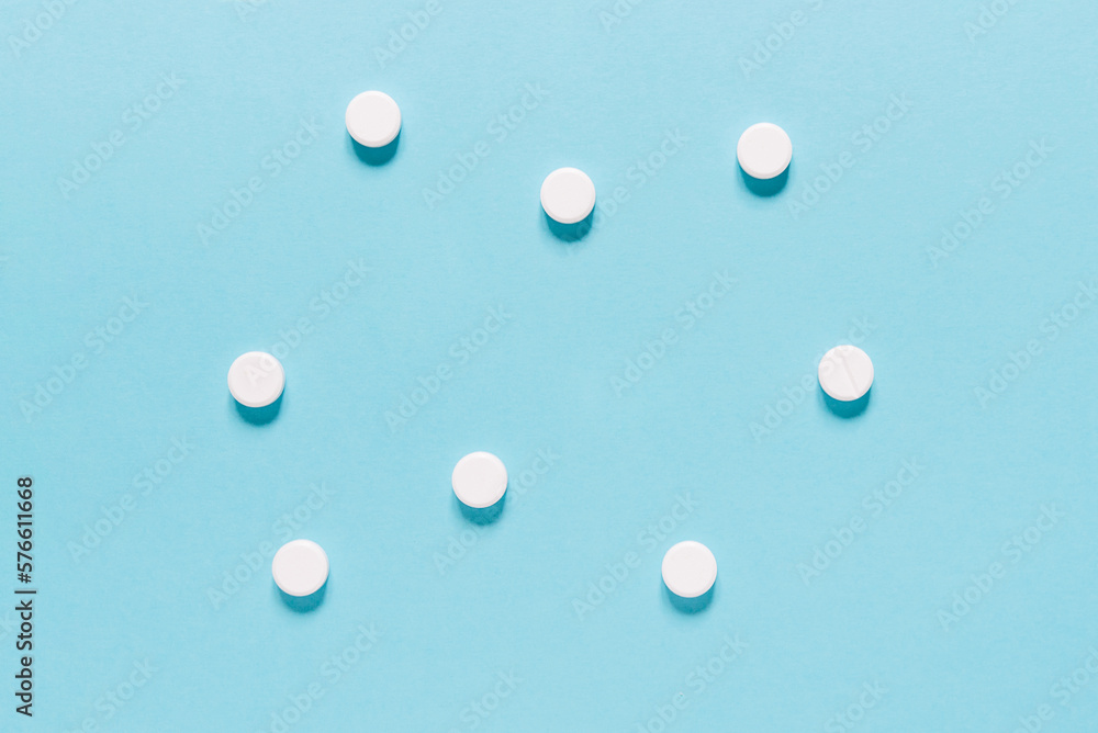 Scattered white pills on blue background. Mock up for special offers as advertising, web background or other ideas. Medical, pharmacy and healthcare concept. copyspace. Empty place for text or logo Scattered white pills on blue background. Mock up for special offers as advertising, web background or other ideas. Medical, pharmacy and healthcare concept. copyspace. Empty place for text or logo