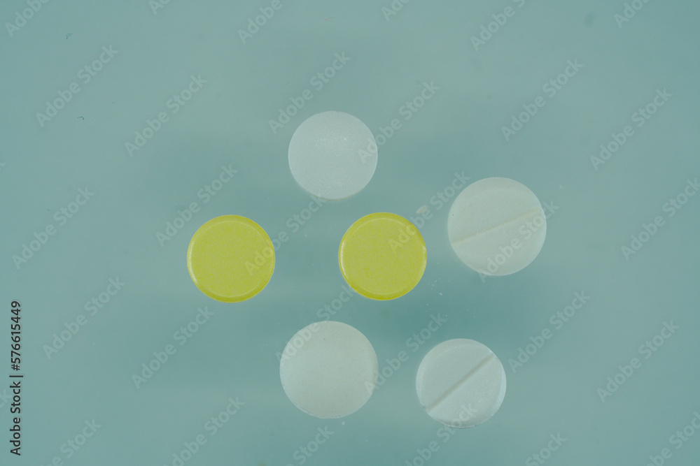 Close up of white pills on a blue background with copy space. Close up of white pills on a blue background with copy space.