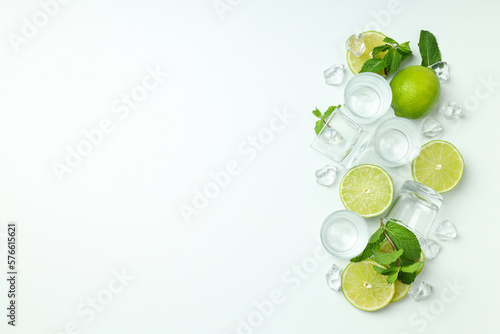 Glasses for shots and ingredients for cocktails on white background