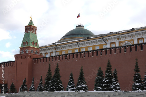 Senate Tower and Senate Palace with State flag of Russian Federation on Cupola view after high red brick Kremlin wall in winter day photo