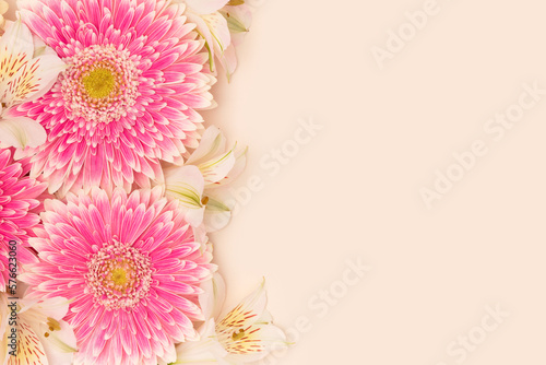 Gerbera and alstroemeria flowers on a beige background. Place for your design.