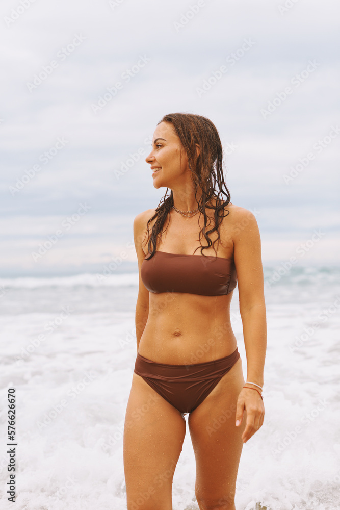 Close up portrait. Young adorable woman is standing and relaxing on the sand beach at the wind Close up portrait. Young adorable woman is standing and relaxing on the sand beach at the wind