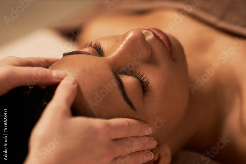Young woman receiving face massage to get glowing and firm complexion