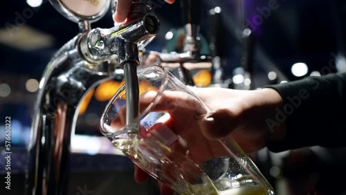 bartender pouring beer from tap in bar, closeup of hands and glass, enjoy fresh ale or lager photo