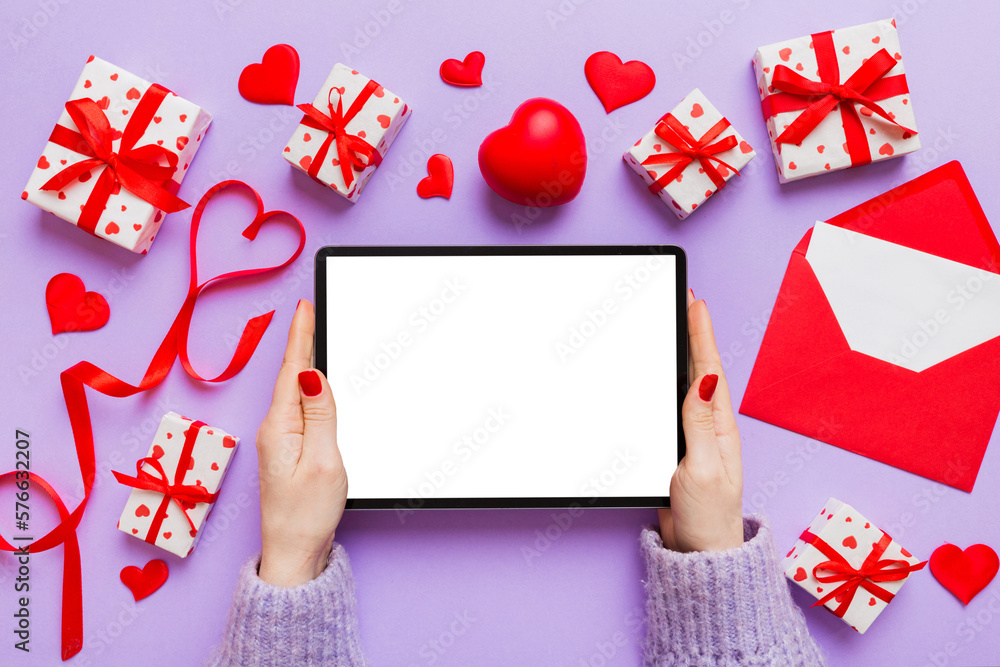 Female hands using a laptop for Valentine day background, gift box and envelope, hearts Female hands using a laptop for Valentine day background, gift box and envelope, hearts