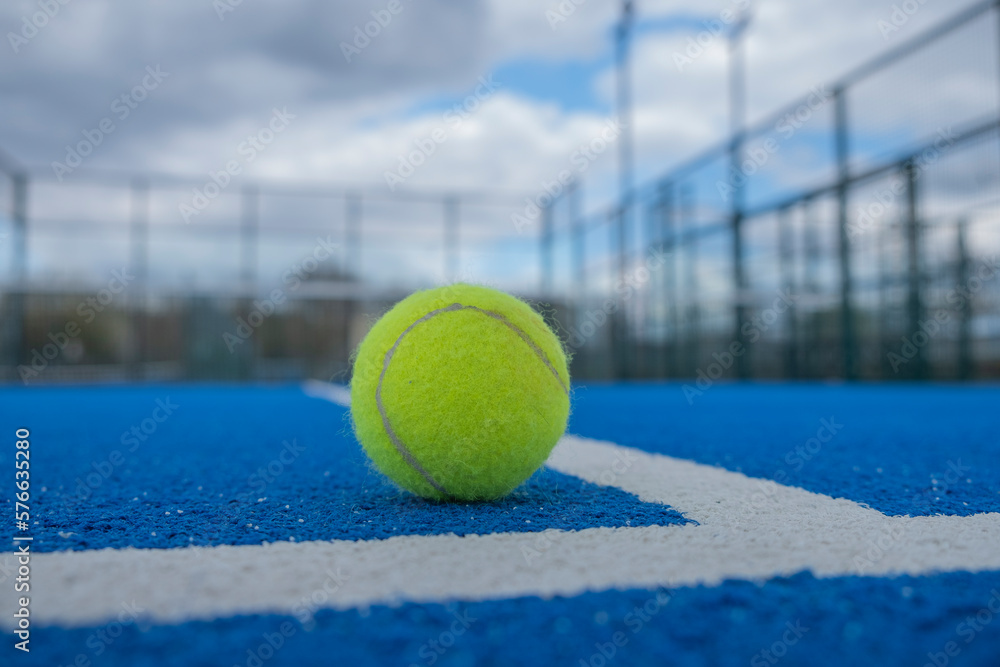 ground level view of a ball in a blue paddle tennis court