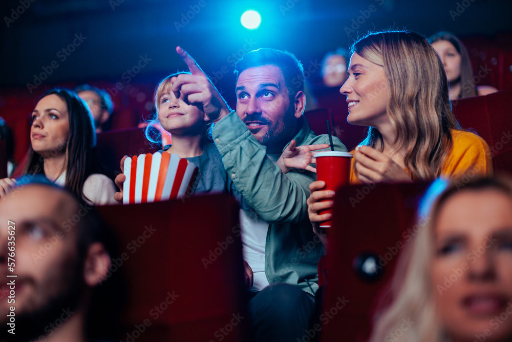 Cheerful family watching movie in theater.