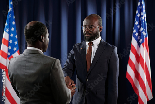 Фотография New president of USA keeping right hand on Holy Bible during oath of office whil