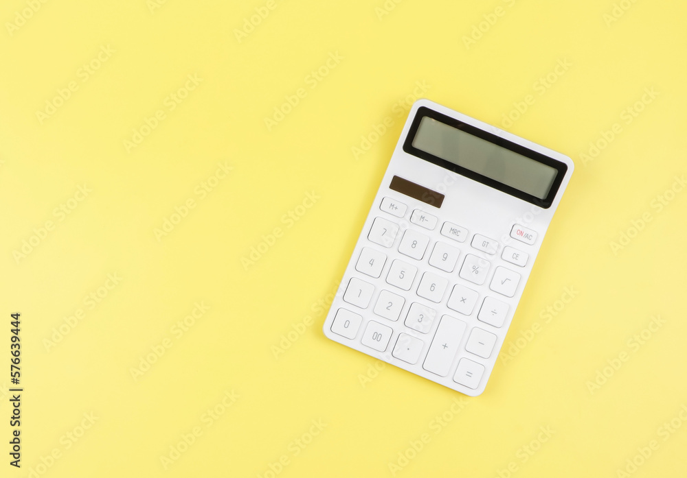 flat lay of white calculator on yellow background with copy space. flat lay of white calculator on yellow background with copy space.