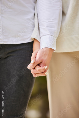 Closeup couple holding hands in park for love  date and marriage commitment together in summer garden. Hand of man  woman and walking outdoor  loyalty and care for partner  trust and calm romance