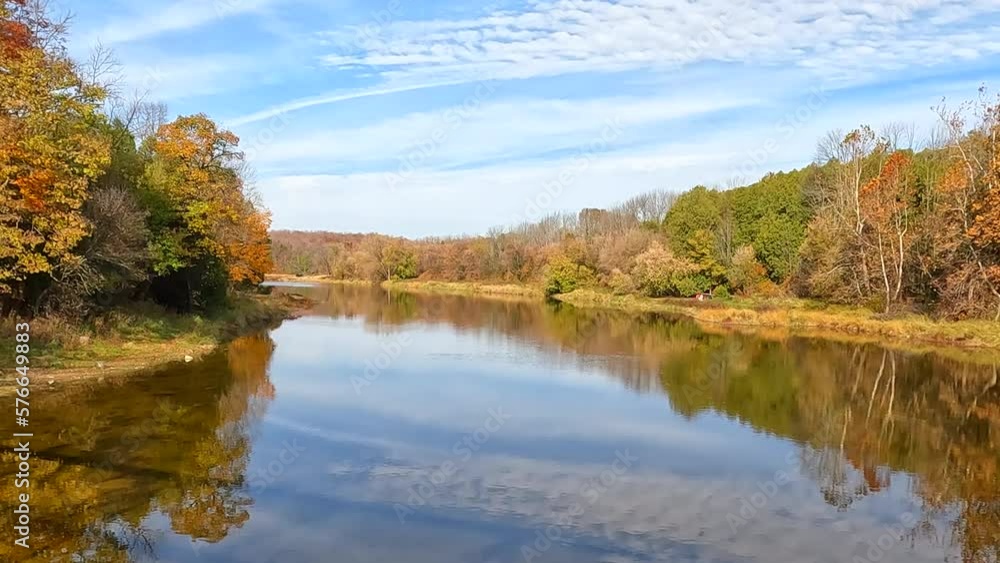 Cloud reflection on calm, tree lined river in the fall. Cloud reflection on calm, tree lined river in the fall.