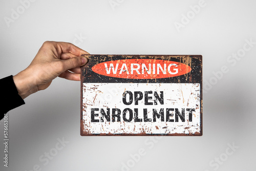 Open Enrollment. Warning sign with text on a white background in a woman's hand