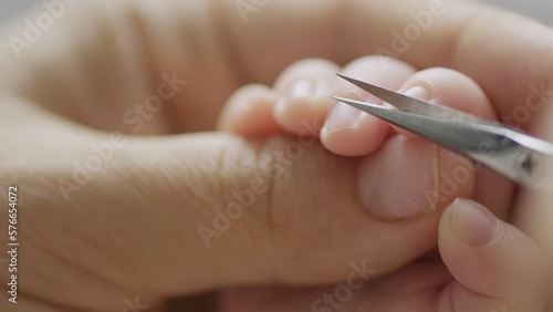 Mother cuts nails of her new born baby. Macro shot of infants nails getting cut. Clipping nails close-up shot.  Child hygeine routine. .