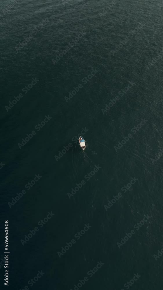 Vertical aerial view of a small boat along the coastline at sunset, Amalfi coast, Italy. Vertical aerial view of a small boat along the coastline at sunset, Amalfi coast, Italy.