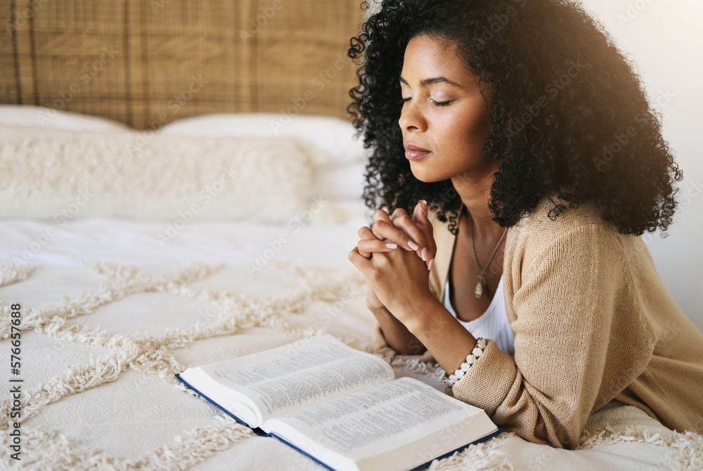 Bible, prayer and black woman praying on bed in bedroom home for