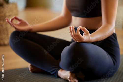 Hands, lotus pose and woman on a floor for yoga, mediation and zen in her living room. Hand, girl and meditation for fitness, peace and balance, chakra and energy training, spiritual and healing photo