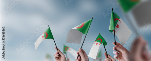 Foto A group of people holding small flags of the Algeria in their hands