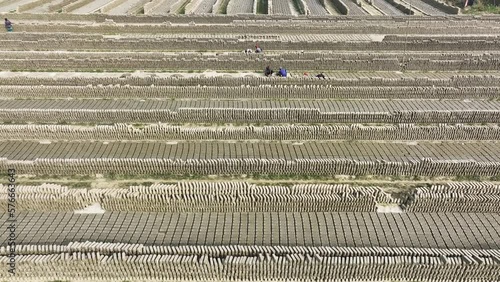 Dhaka, Bangladesh - 27 February 2023: Aerial view of a brick factory from above, people working arranging the bricks near Keraniganj township. photo