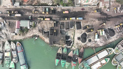 Aerial view of people with trucks working along the riverbank unloading coal, Bhairab Upazila, Bangladesh. photo