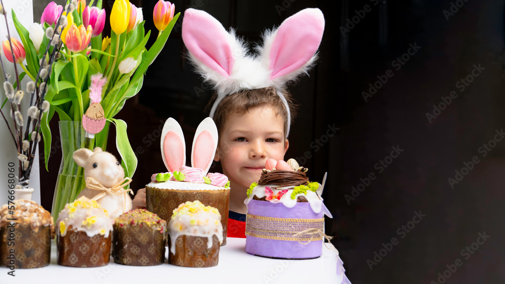Cute little boy with bunny ears looking at tasty easter sweet cake Cute little boy with bunny ears looking at tasty easter sweet cake