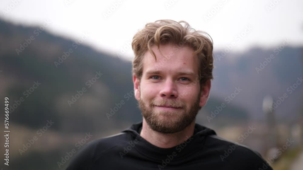 a somewhat serious-looking man winks at the cute cameraman before giving a nice laugh, obviously delighted. His wavy hair is a little sloppy. In the background is a blurred landscape. a somewhat serious-looking man winks at the cute cameraman before giving a nice laugh, obviously delighted. His wavy hair is a little sloppy. In the background is a blurred landscape.