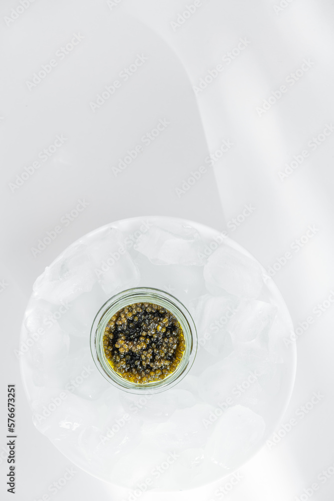 Premium caviar black in glass jar and ice cube