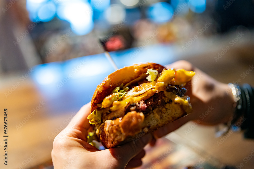 man hands hold fast food burger in pub man hands hold fast food burger in pub