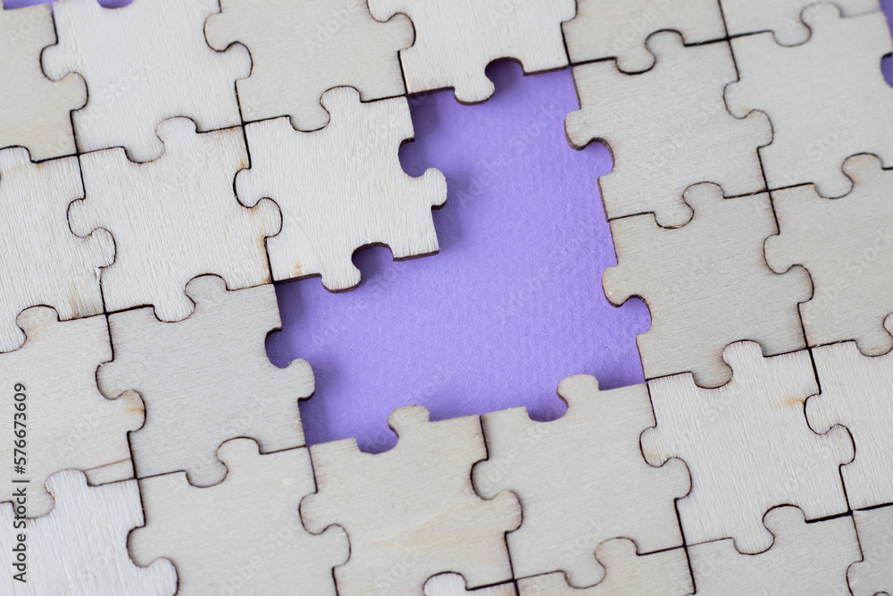 Missing heart-shaped puzzles. A background of puzzles with a light purple empty space. Missing heart-shaped puzzles. A background of puzzles with a light purple empty space.