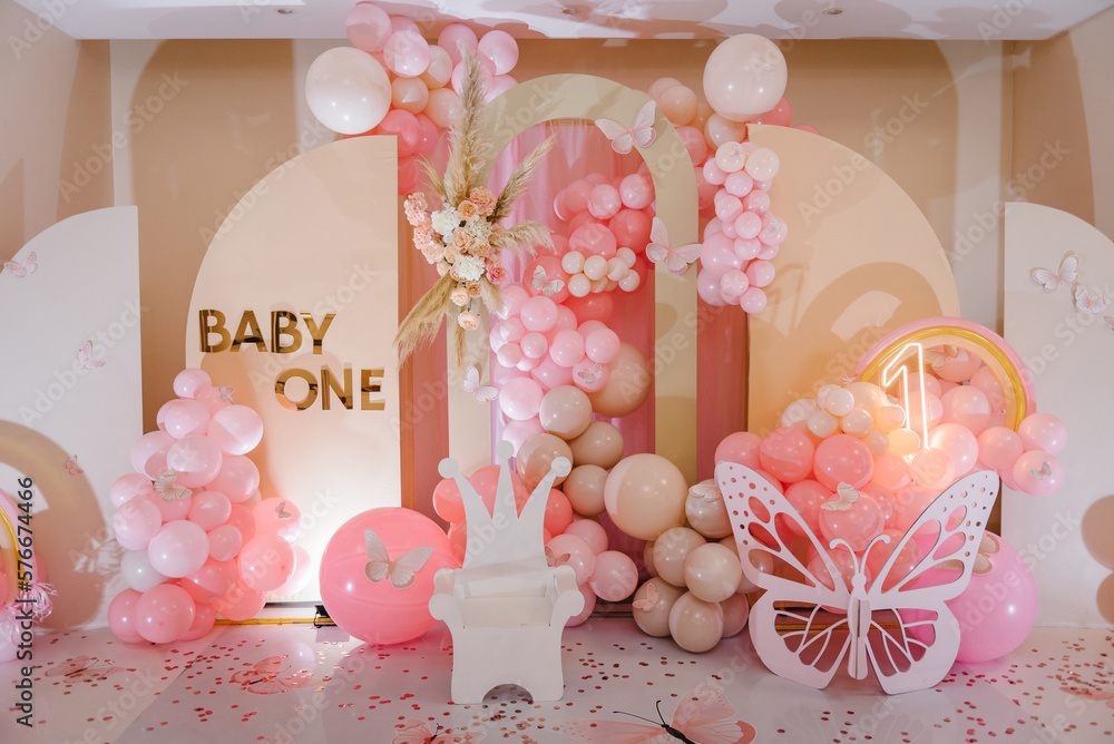 Arch decorated pink balloons, rainbow, text baby one, flowers, paper