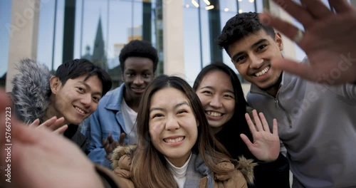 Happy group of multiracial friends millennials taking a selfie together or having a video call