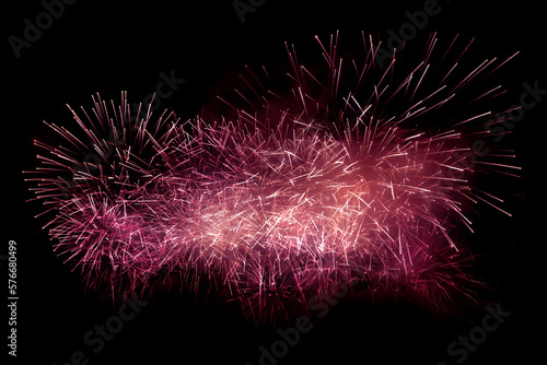 Beautiful red fireworks display lights up the sky with dazzling display during New Year celebration. Abstract colored fireworks background with copy space. Celebration and anniversary concept