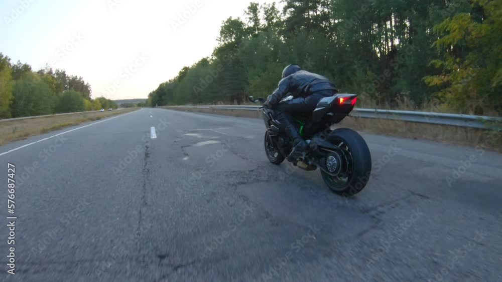 Aerial shot of motorcyclist riding on modern sport motorbike at autumn highway. Biker racing his motorcycle on country road. Guy driving bike during trip. Concept of freedom and adventure at journey Aerial shot of motorcyclist riding on modern sport motorbike at autumn highway. Biker racing his motorcycle on country road. Guy driving bike during trip. Concept of freedom and adventure at journey