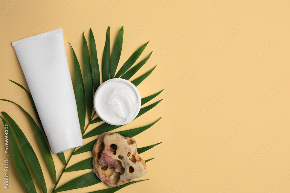 Cosmetic products, palm leaf and beautiful stone on beige background, flat lay. Space for text Cosmetic products, palm leaf and beautiful stone on beige background, flat lay. Space for text