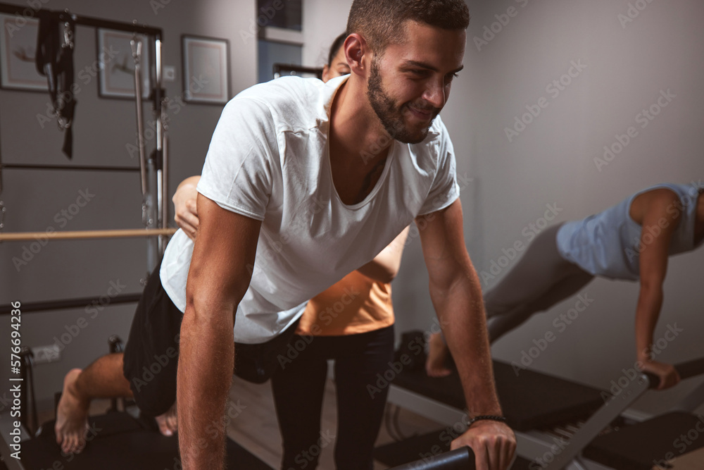 Young women and man exercising in a gym with personal trainer. Young women and man exercising in a gym with personal trainer.