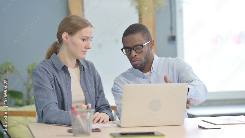 African Businessman Talking with Businesswoman, Discussing Paperwork