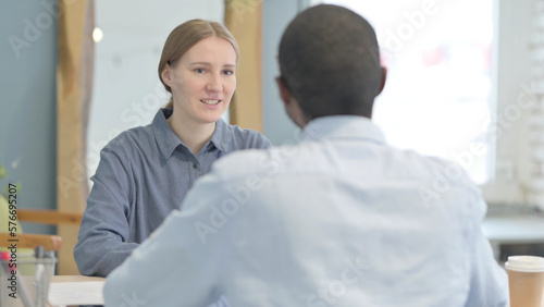 Young Woman Talking to African Man in Office