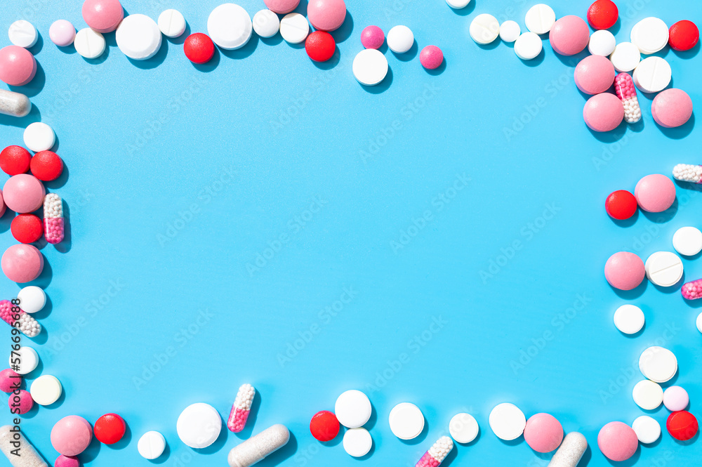 Medical pharmaceutical health care background. Assorted of colorful tablets, capsules, pills, vitamins on blue background. Flat lay top view copy space. Pill frame, minimalist mockup