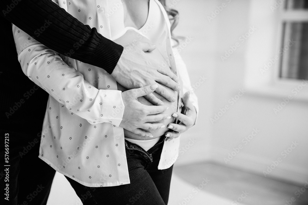 a man's hand on the stomach of a pregnant woman. 