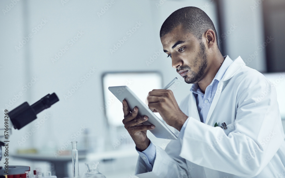 Research plays a big role in solving problems. Shot of a scientist recording his findings on a digital tablet.