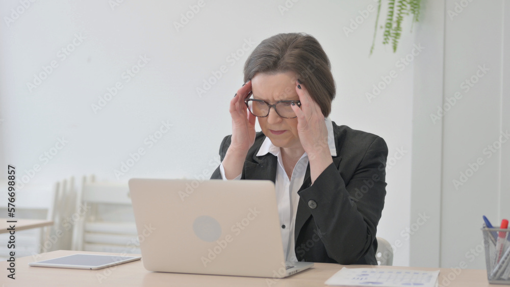 Old Businesswoman having Headache while Working on Laptop Old Businesswoman having Headache while Working on Laptop