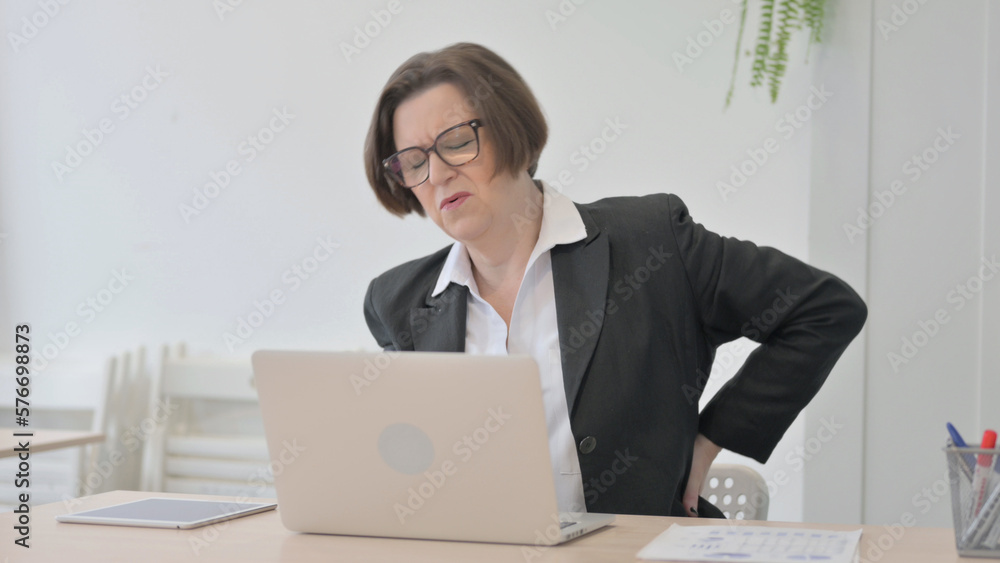 Old Businesswoman having Back Pain while using Laptop Old Businesswoman having Back Pain while using Laptop