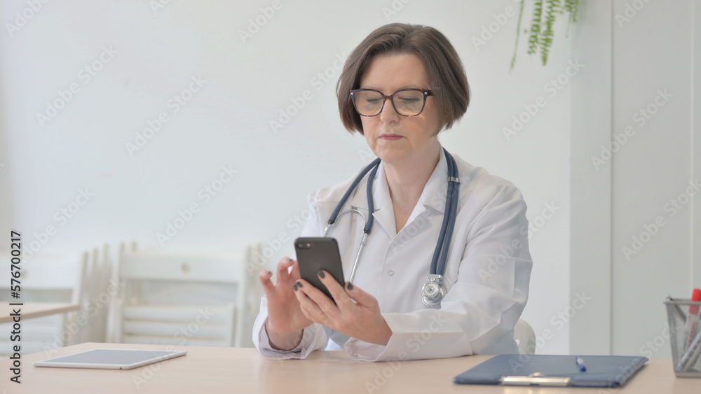 Senior Doctor Browsing Smartphone in Clinic Senior Doctor Browsing Smartphone in Clinic