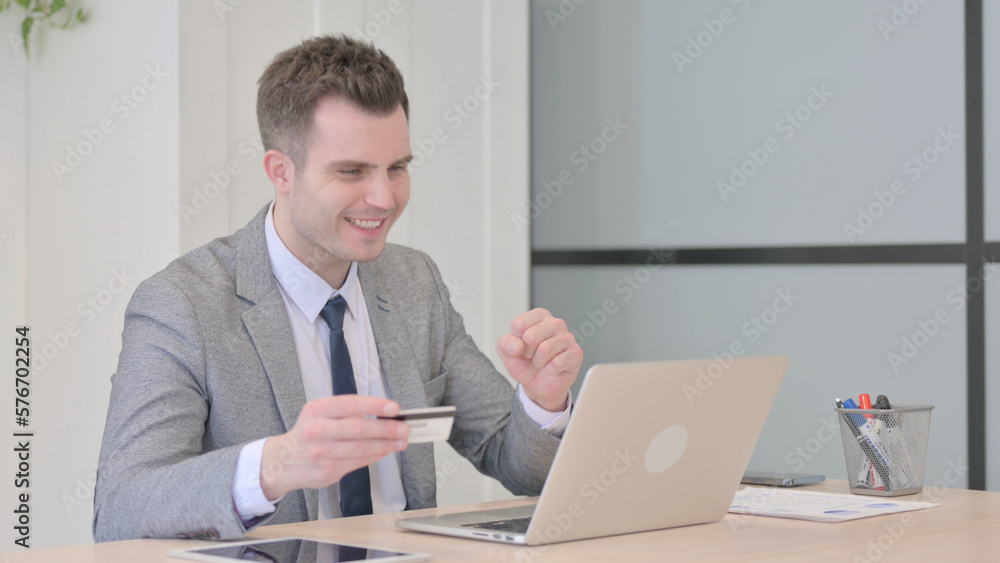 Young Businessman making Successful Online Payment on Laptop Young Businessman making Successful Online Payment on Laptop