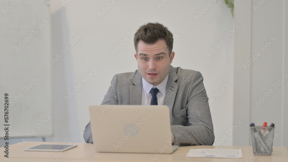 Young Businessman Reacting to Loss While Working in Office Young Businessman Reacting to Loss While Working in Office