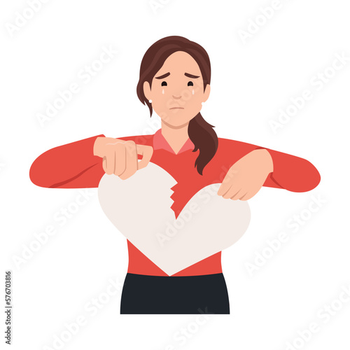 woman hand tearing apart a paper heart. broken heart and sad emotionally.