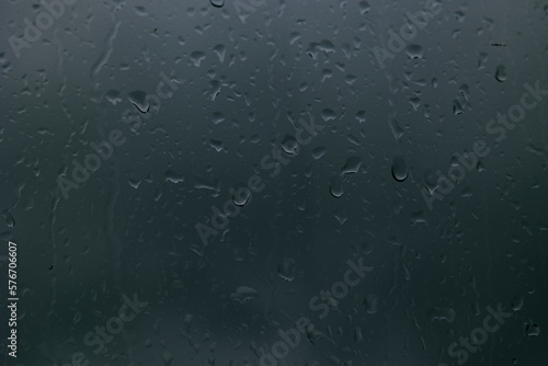 Moody background photo. Raindrops on the window. Defocused water drops.