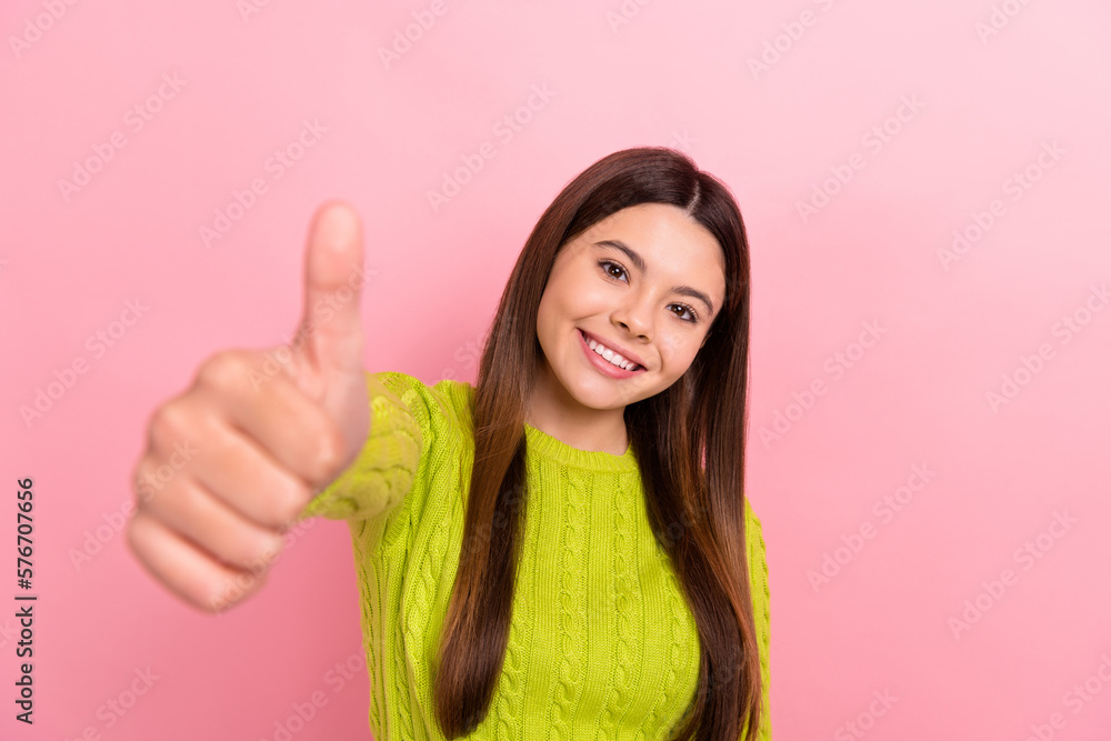 Photo portrait of lovely teen lady showing thumb up good quality dressed stylish green clothes isolated on pink color background Photo portrait of lovely teen lady showing thumb up good quality dressed stylish green clothes isolated on pink color background