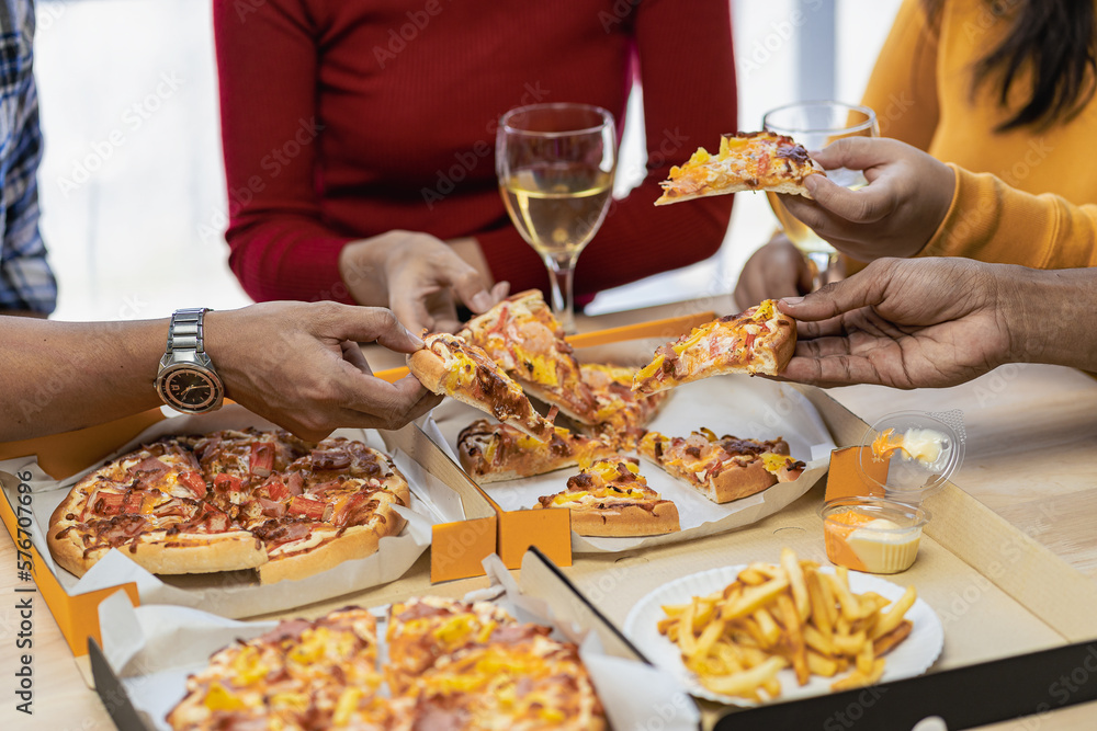 Group of employees eating Italian pizza Hand picked pizza in a lunch or dinner shop. Tasty seafood gravy sauce. Traditional Italian fast food on wooden table with drinking wine. Group of employees eating Italian pizza Hand picked pizza in a lunch or dinner shop. Tasty seafood gravy sauce. Traditional Italian fast food on wooden table with drinking wine.